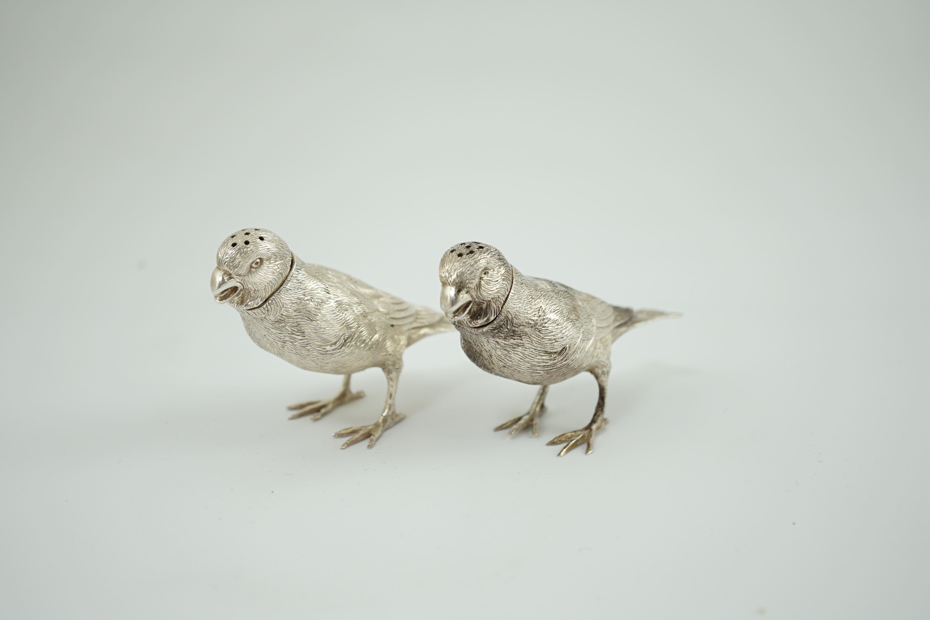 A pair of Elizabeth II silver novelty free-standing pepperettes, modelled as sparrows, by Israel Freeman & Son Ltd